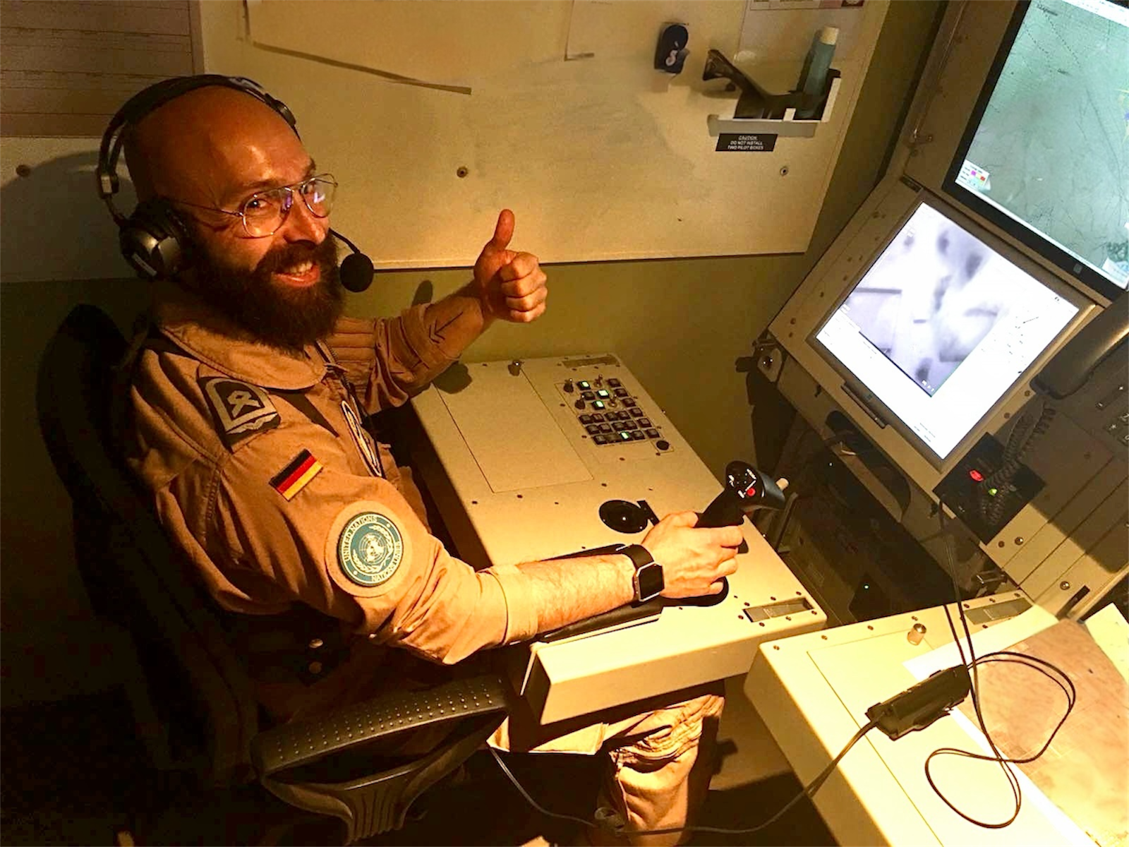 André Hassan Khan mit Headset und Joystick an der Konsole als Human-Machine-Interface des Aufklärungssystems Heron 1